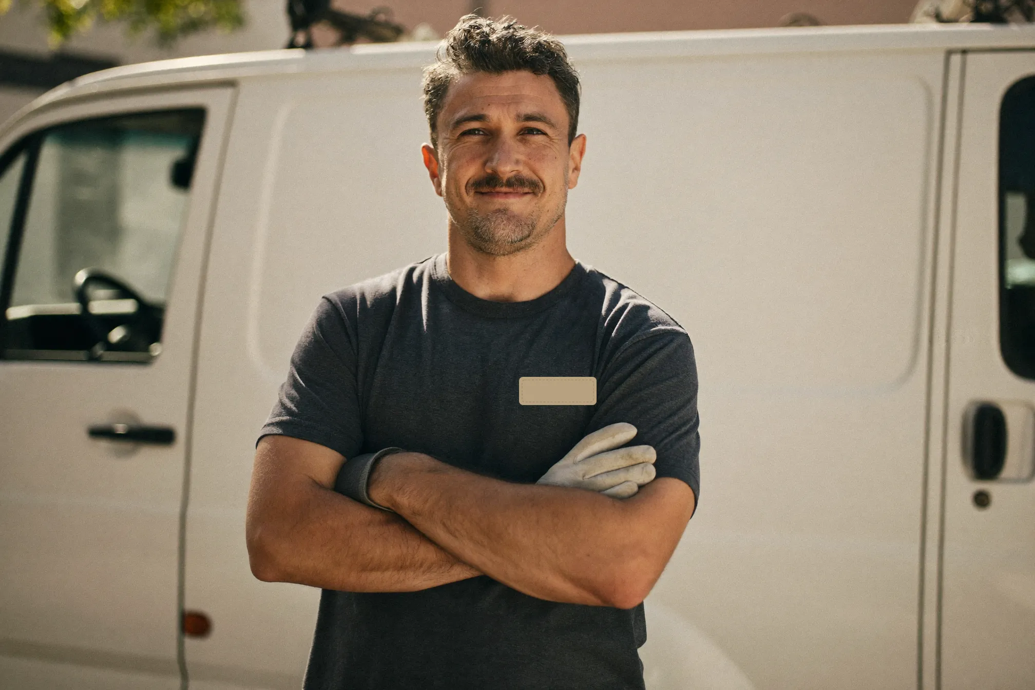 Marco Rivera, the licensed owner of Rivera Plumbing, standing in front of his service van